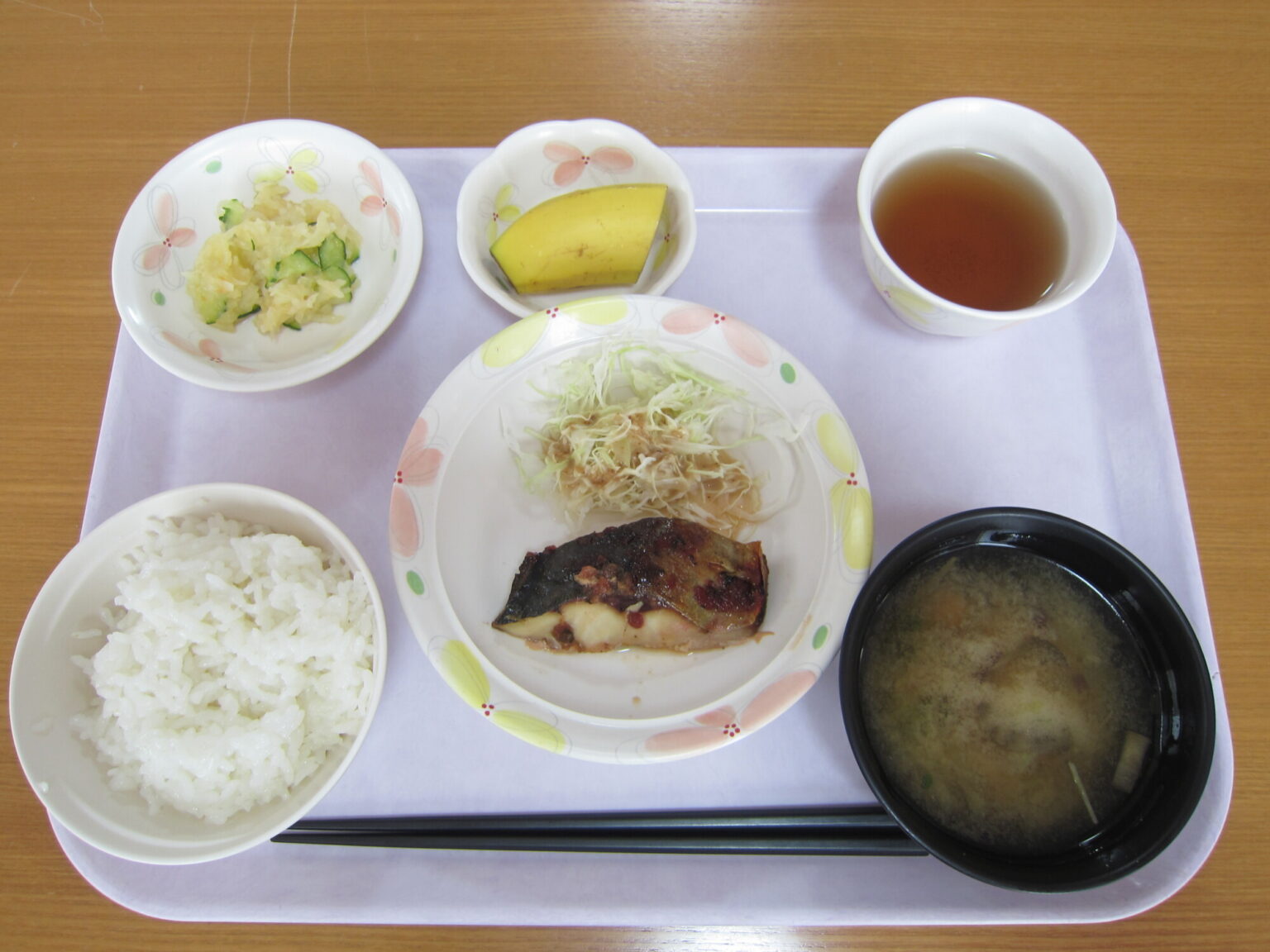 介護施設の配食。白飯、焼魚、野菜、汁物がトレーに配置された昼食